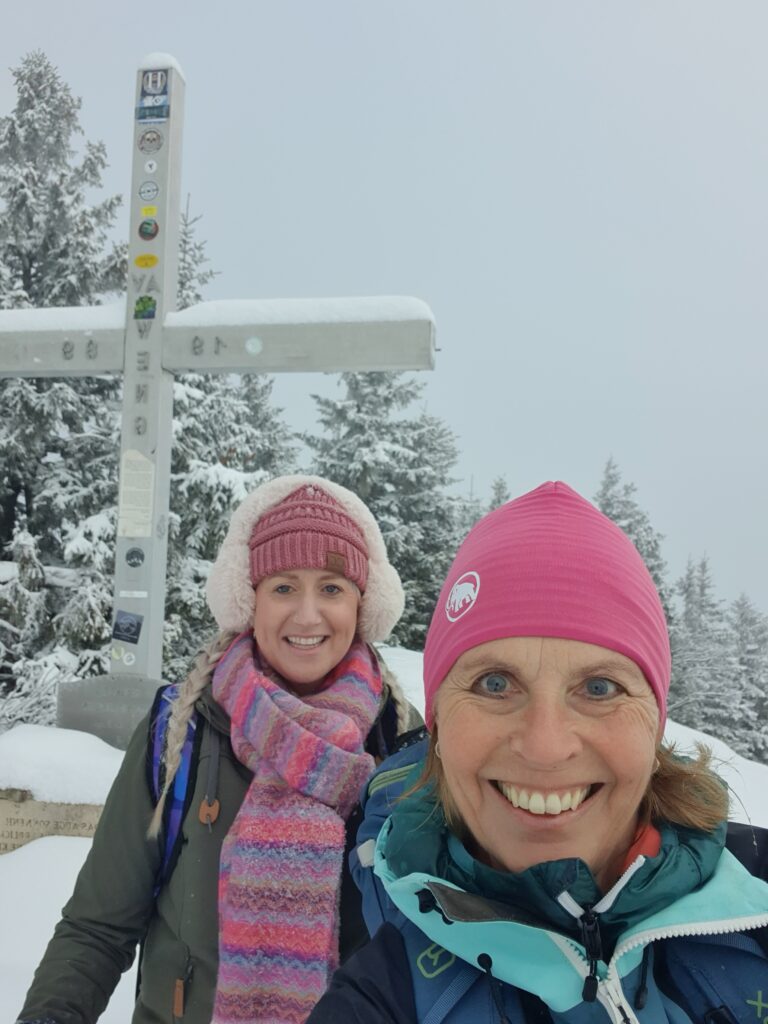 Schneeschuhwanderung Salzburg – Wanderer vor Gipfelkreuz
