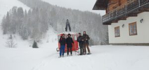 Schneeschuhwanderung Salzburg – Wanderer vor gemütlicher Almhütte