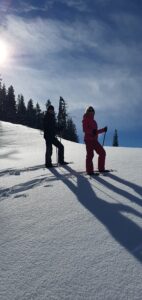 Schneeschuhwanderung Salzburg – Wanderer auf verschneitem Gipfel mit Alpenpanorama im Salzburger Land